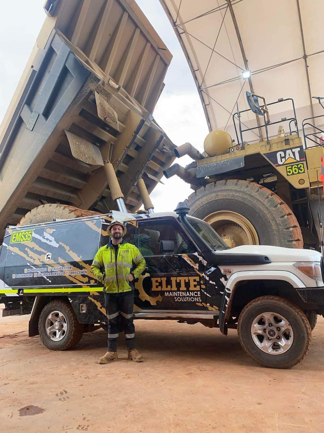 Elite fitter Aaron in front of a Cat 793 haul truck — Cornishman millfeed campaign